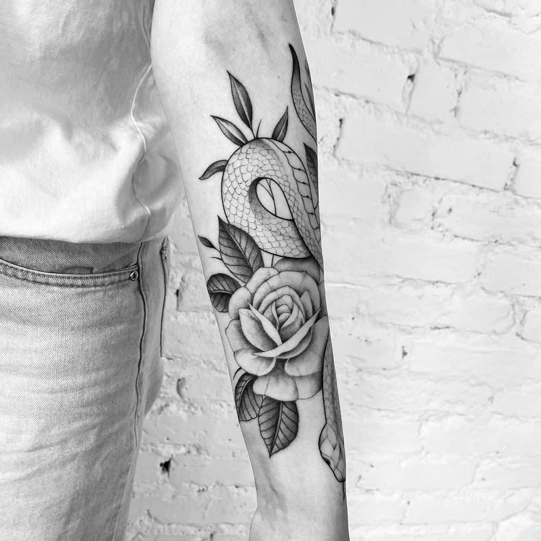 Snake and rose tattoo on the left forearm