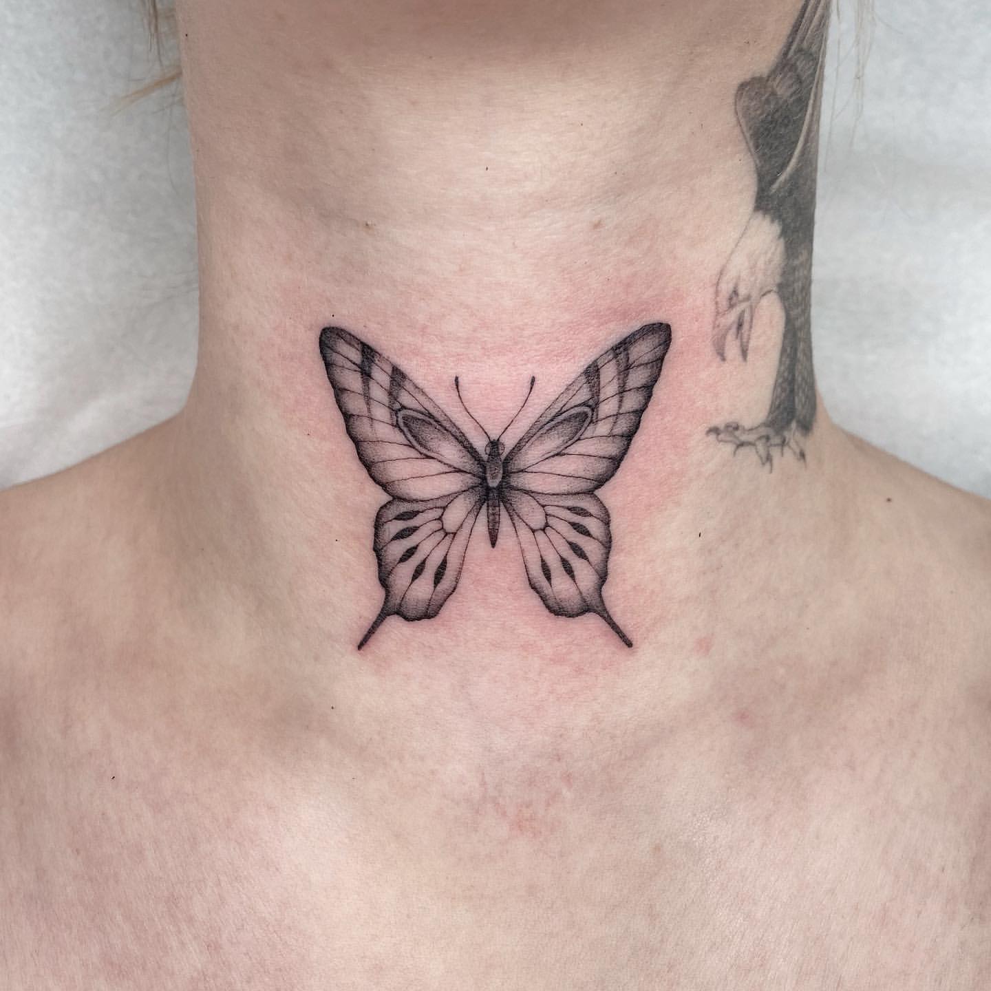 Butterfly tattoo on the back of the neck