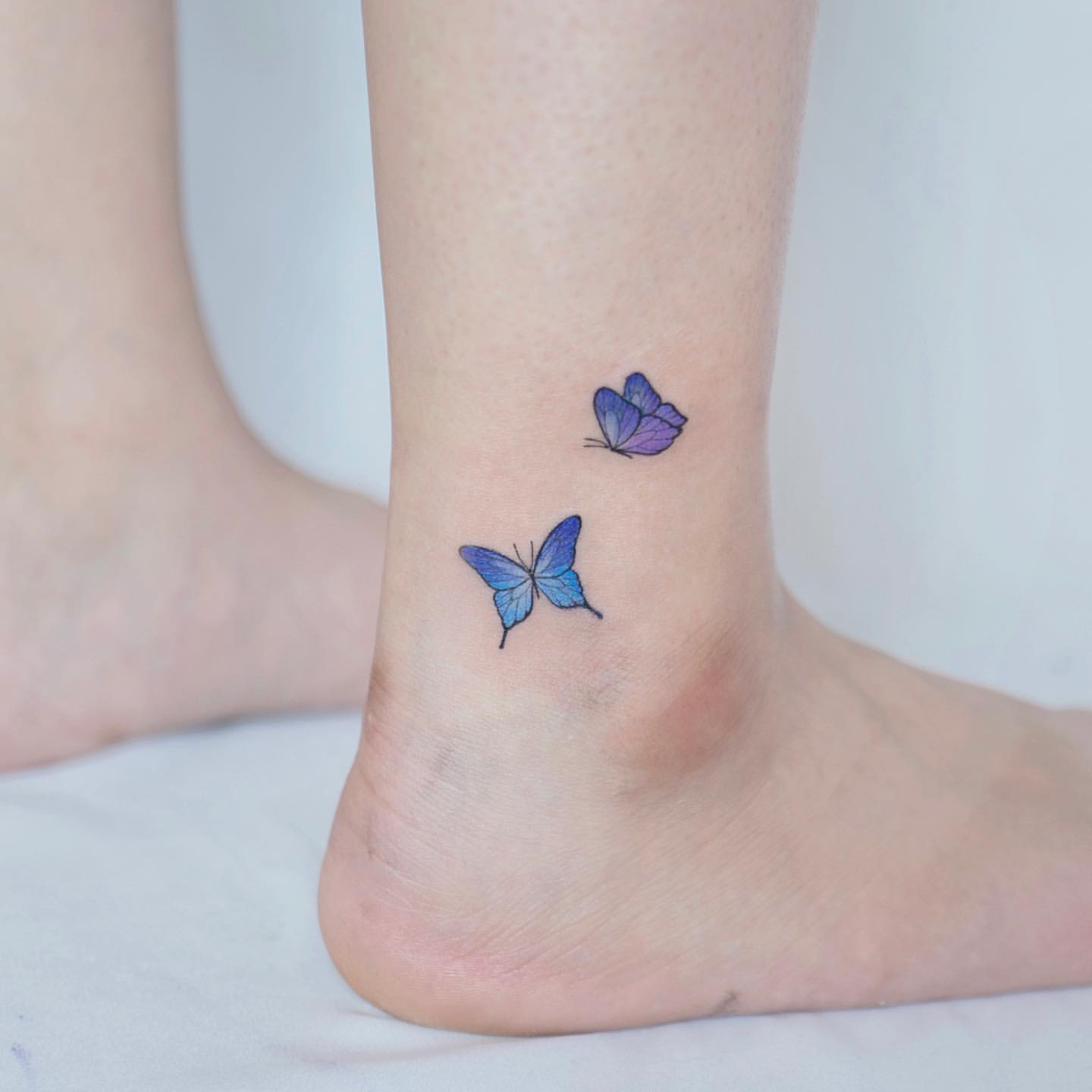 Blue butterfly tattoo ankle