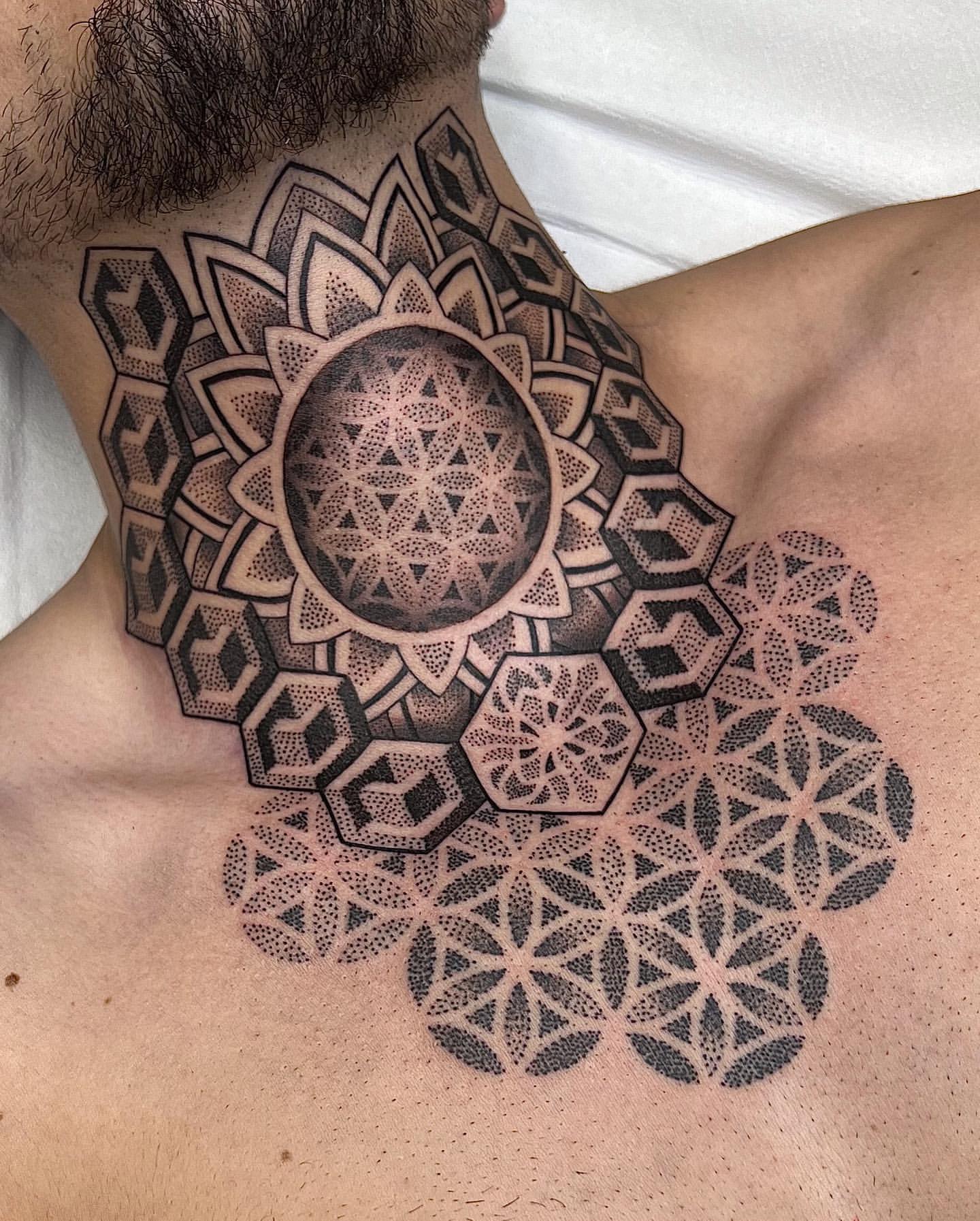 Large black mandala tattoo on the chest and shoulder - Tattoogrid.net